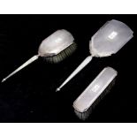 A three-piece silver dressing table set, Birmingham 1962, comprising hand mirror, hair brush and