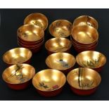 Eighteen Japanese red lacquer bowls with gilt interiors, each decorated with fish, birds and