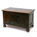 A 17th century style oak coffer on bun feet, 92cms (36ins) wide.