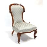 A Victorian walnut spoon-back nursing chair with upholstered seat and back.