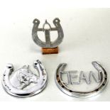 Three lucky horseshoe radiator grille badges, the largest 12cms (4.75ins) wide (3).