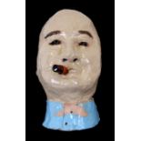 A moulded and glazed pottery mask in the form of Winston Churchill smoking a cigar, 33cms (13ins)