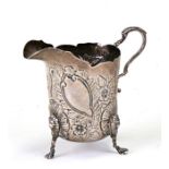 A silver cream jug decorated in relief with a fox amongst flowers on lion masked capped legs,