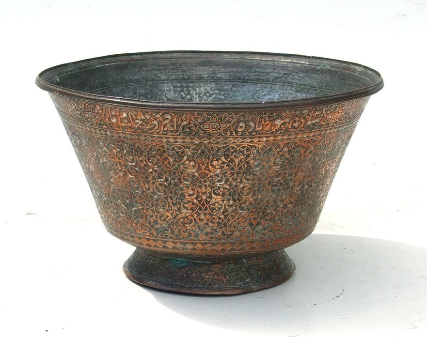 A heavy Persian / Islamic copper bowl highly decorated with foliate scrolls and script to the