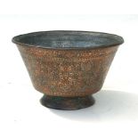 A heavy Persian / Islamic copper bowl highly decorated with foliate scrolls and script to the