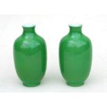 A pair of Chinese green monochrome vases with blue seal mark to the underside, 16cms (6.25ins)