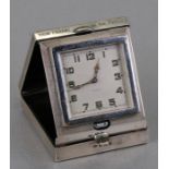 A silver eight-day travel clock, Birmingham 1934, the case initialled 'JEHL' with inscription.