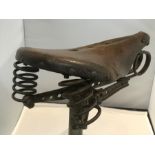 A vintage leather and sprung saddle by Ideale of France, mounted on a plinth