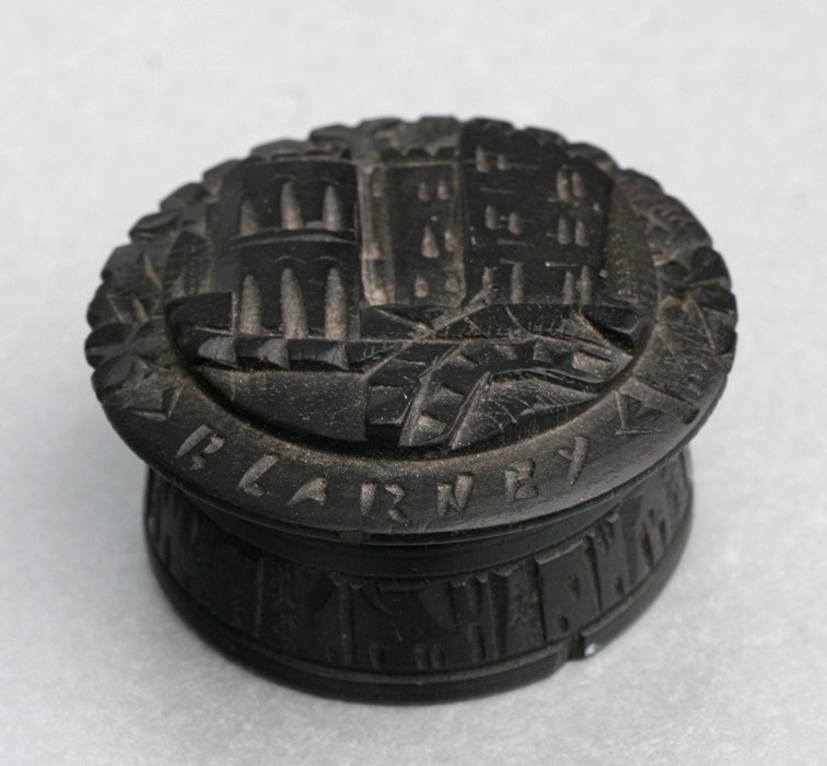 A Victorian Irish bog oak box, the top carved with Blarney Castle. 6cm (2.25 ins) diameter