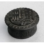 A Victorian Irish bog oak box, the top carved with Blarney Castle. 6cm (2.25 ins) diameter