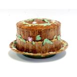 A Victorina majolica stilton cheese dish and cover decorated with scrolling, flowering foliage,