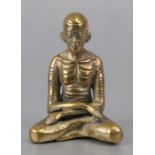 A bronze seated figure in the form of an emaciated monk, 10cms (4ins) high.