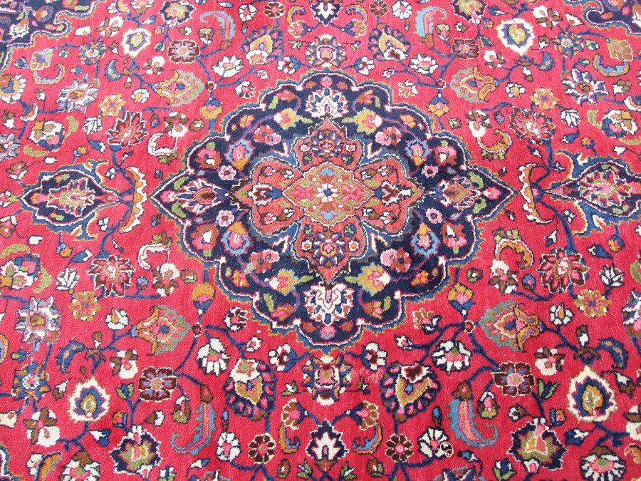 A Persian Tabriz rug with central medallion within foliate scrolls on a red ground, 210 by 305cms ( - Image 2 of 2