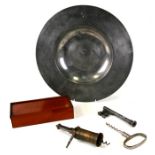 A pewter charger, 36cms (14ins) diameter; together with two corkscrews and a mahogany boxed set of