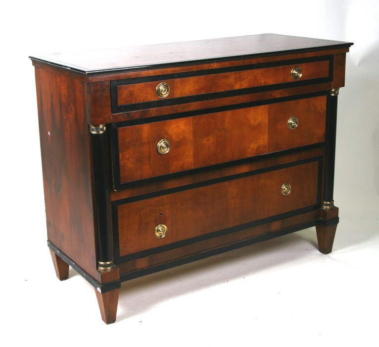 A Biedermeier style chest of three graduated long drawers flanked by ebonised pillars, 106cms (41.