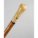 An ivory handled walking cane, the crown pique initialled 'I. B', pierced for tassel, above an ebony