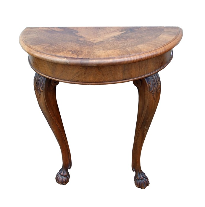 A walnut demi-lune console table on acanthus capped cabriole legs with paw feet, 74cms (29ins)