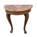 A walnut demi-lune console table on acanthus capped cabriole legs with paw feet, 74cms (29ins)