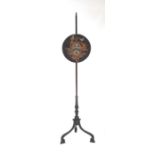 A 19th century rosewood pole screen with circular needlework panel, on a tripod base.