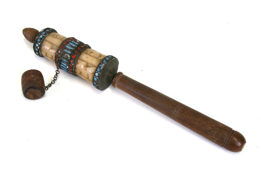 A Tibetan prayer wheel with jade type carved panels, 25cms (10ins) long.