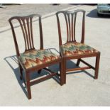 A pair of Georgian mahogany chairs with upholstered drop-in seats, on square chamfered front