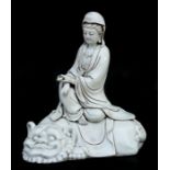 - A Chinese Blanc de Chine style figure, depicting Guan Yin sat on a temple lion. 30cm 12ins high.