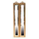 A pair of gilt framed bevel edged mirrors, each 20 by 121cms (8 by 47.5ins).