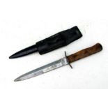 A WW2 German fighting knife with wooden studded grip handle in its steel scabbard with leather frog.