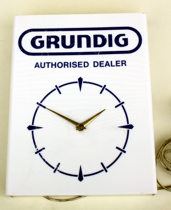 An original GRUNDIG authorised dealer electric wall clock, 30cm (12 ins) wide