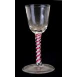 An 18th century wine glass with cranberry and opaque double air twist stem, 14.5cms (5.75ins) high.