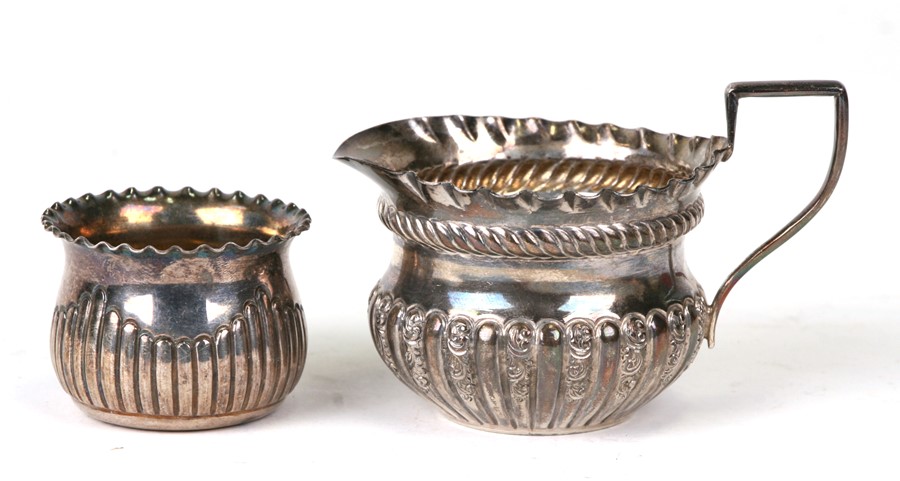 A silver cream jug and similar silver sugar bowl (2).