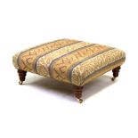 A large modern footstool with upholstered seat on turned legs and brass casters, 31 by 31ins wide,