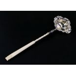 A large long ivory handled un-hallmarked silver toddy ladle, 45cms (17.75ins) long.