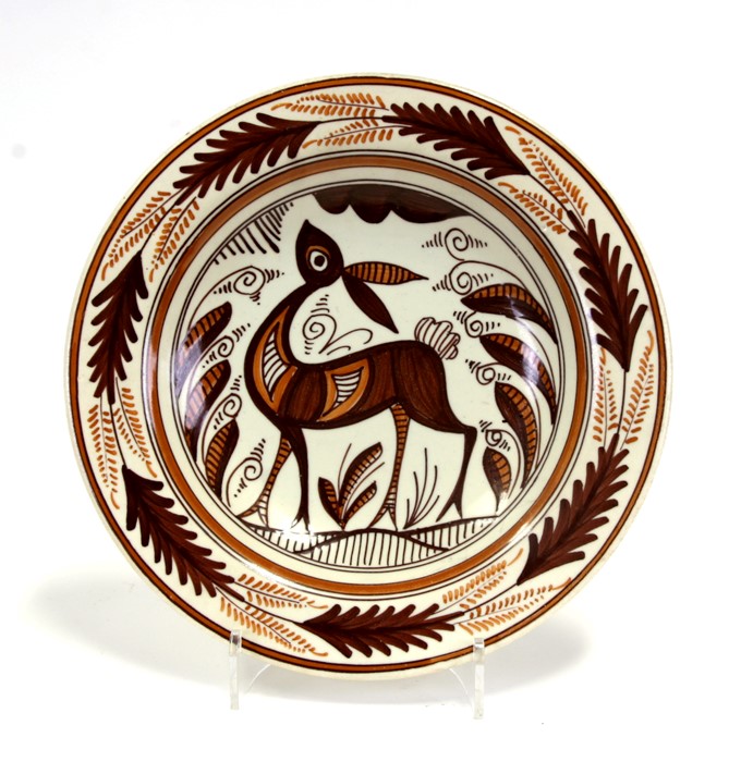 A mid 20th century pottery charger decorated with a stylised deer, 34cms (13.5ins) diameter.