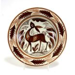 A mid 20th century pottery charger decorated with a stylised deer, 34cms (13.5ins) diameter.