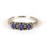 A 9ct white gold ring set with three pale purple stones interspersed with diamonds, weight 2.4g,