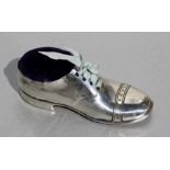 A silver novelty pin cushion in the form of a shoe, Birmingham 1911, 13cms (5ins) long.