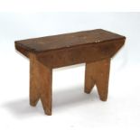 A rustic pine stool, 61cms (24ins) wide.