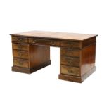 A late 19th / early 20th century Victorian pedestal desk, the leather inset top above an arrangement