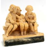 An early 20th century plaster group depicting three children seated on a bench, 30cms (12ins)