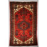 A Persian Hamadan hand knotted woollen rug with stylised design within borders, on a red ground, 159