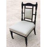 In the manner of Godwin, a Victorian ebonised nursing chair with upholstered seat, on turned front