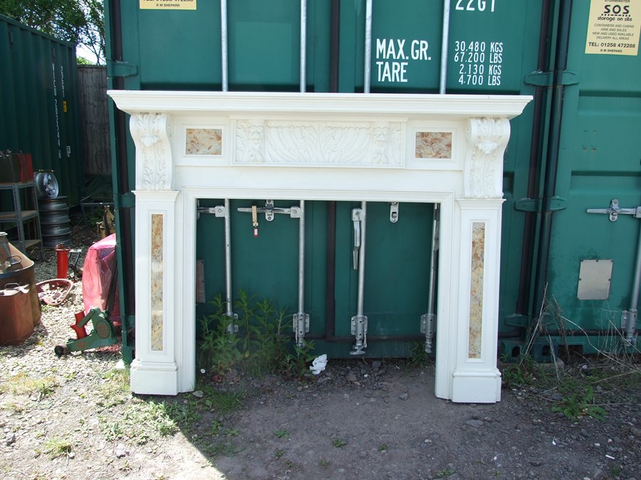 A large Adams style painted fire surround with carvings of the Green Man and inset granite panels,