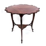 An Edwardian mahogany two-tier occasional table of triangular form with three drop flaps, on