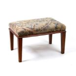 A walnut stool with needlework upholstered seat, 61cms wide.