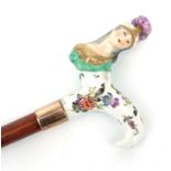 An antique porcelain handled walking cane, the handle in the form of the bust of Minerva with 18ct