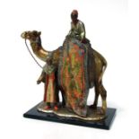 After Franz Bergman, a cold painted spelter table lighter in the form of a camel with two carpet