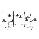 Four late 19th century patinated brass twin light candelabra in the Gothic Revival style, each