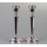 A pair of Adam style silver dwarf candlesticks with tapering hexagonal columns, Birmingham 1975,