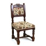 A 17th century style oak hall chair with carved back rail, padded seat and back, on turned front